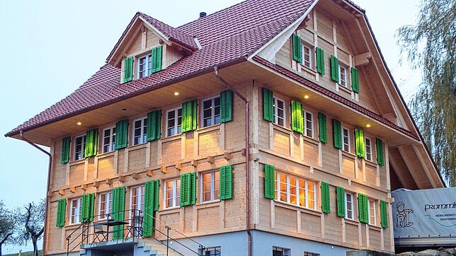 Ein Thoma Holz100-Haus mit traditioneller Ständer-Bohlen-Fassade, das moderne Technik und nachhaltige Bauweise harmonisch vereint. ...