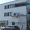 Die Maler legen letzte Hand an und verzieren die Hauswand mit dem Logo "Haus am Teuringer".