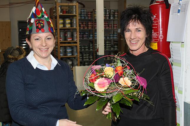 Ochsenbachkurier-Redakteurin Annika Rössler (links) überreicht Blumen an die superschnelle Chef-Layouterin Conny Jelitte.