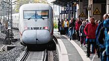 Fahrgäste stehen neben einem ICE am Bahnhof Hannover Messe. In den nächsten Jahren will die Bahn ihr Schienennetz umfangreich erneuern. ...