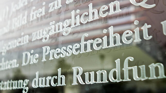 Das Wort Pressefreiheit in einem Ausschnitt des Artikels 5 des Grundgesetzes auf einer Scheibe eines Bundestags-Gebäudes ...