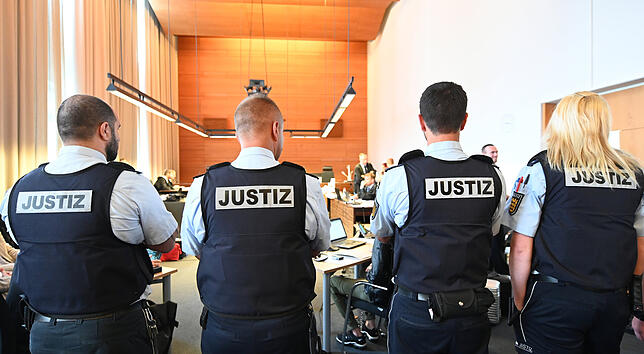 Justizbeamte stehen im Gerichtssaal des Landgerichts.