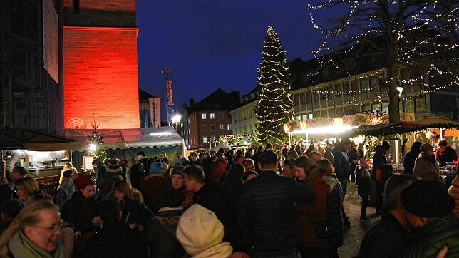 Weihnachtliche Stimmung auf dem Marktplatz in Radolfzell mit einem rot getönten Münsterturm und Lichterketten in den Bäumen: Der ...