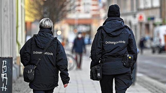 Zwei Mitarbeiterinnen der Ordnungsbehörde laufen durch die Innenstadt von Erfurt. Die Sieben-Tage-Inzidenz ist in Thüringen gesunken, ...