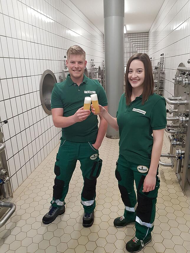 Sina Zimmermann verkostet zusammen mit ihrem Kollegen Stefan Müller im Keller der Brauerei vor den Lagertanks das Bier.