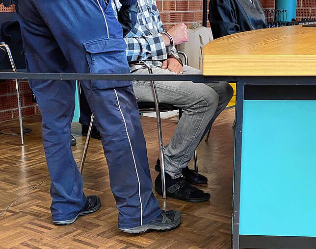 Die Handfesseln werden dem Angeklagten zu Beginn der Verhandlung abgenommen.