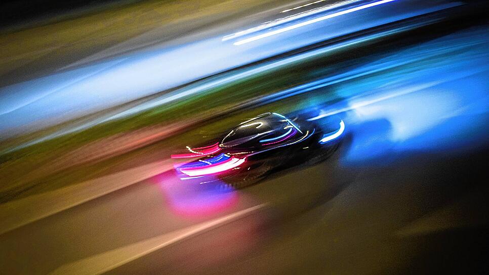 Zu Lichtspuren verwischt ist dieser Pkw, der über eine deutsche Autobahn brettert.