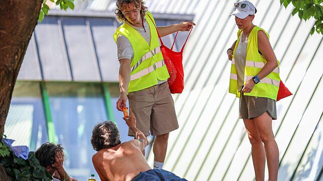 Willi Glück (links) und Janine Funk vom Stuttgarter Hitzebus verteilen Sonnencreme und Wasser an Obdachlose.