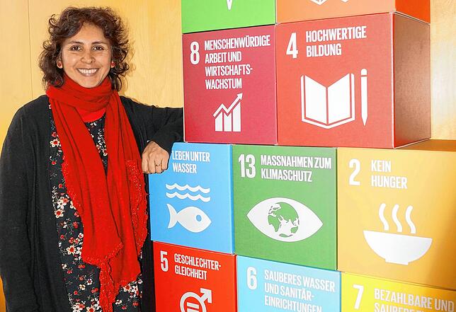 Cristina Aguirre mit den 17 Zielen der Agenda 2030, die eine Veränderung in Politik und Gesellschaft anstoßen und dazu beitragen sollen, ...