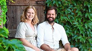 Michael und Olivia Schmidl auf einer Treppe hinter der Scheune, in der die beiden schon bald eigenes Bier herstellen wollen.