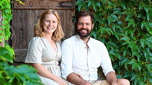 Michael und Olivia Schmidl auf einer Treppe hinter der Scheune, in der die beiden schon bald eigenes Bier herstellen wollen.
