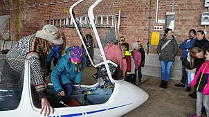 Leo Janke erklärt einem Mädchen das Cockpit eines Segelfliegers.