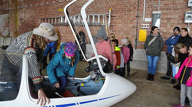 Leo Janke erklärt einem Mädchen das Cockpit eines Segelfliegers.