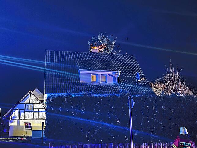 Bereits beim Eintreffen der Einsatzkräfte sind Flammenzungen und Funkenflug aus dem Schornstein zu sehen.
