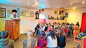 Oberzunftmeister Jonny Kienzler (links am Pult) erzählt den Kindern von der Schonacher Fasnacht. Bei dem Besuch sollen auch Ängste ...