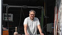 Jürgen Kübler vor seiner Werkstatt, an seinem aktuellen Werkstück, einen Sockel für ein Wegkreuz. Foto: Rotraud Opfermann