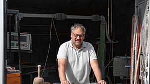 Jürgen Kübler vor seiner Werkstatt, an seinem aktuellen Werkstück, einen Sockel für ein Wegkreuz. Foto: Rotraud Opfermann