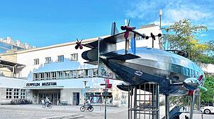 Ein Spiel-Zeppelin ziert den Buchhornplatz in Friedrichshafen, direkt dahinter das Zeppelin Museum.