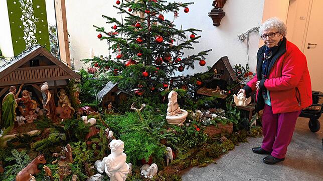 Ursula Bäuerle stellt die letzte fehlende Figur, einen Engel, in den Krippenaufbau.