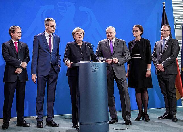 Bundeskanzlerin Angela Merkel (CDU) steht nimmt 2016 das Gutachten zur Wirtschaftsentwicklung zwischen dem Vorsitzenden des ...