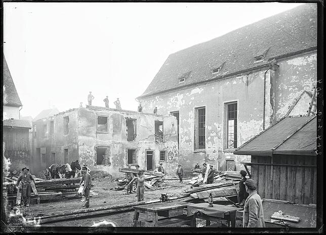 Abrissarbeiten und Aufräumarbeiten neben der Pfarrkirche St. Oswald. Hier wird der Löwen abgerissen, damit die Kirche 1932/33 neu und ...