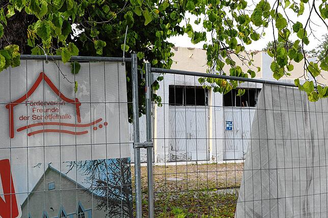 Ein Bauzaun sperrt das Gebiet der Scheffelhalle ab. Daran sind Plakate unter anderem des Fördervereins befestigt.