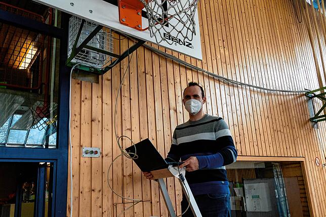 Otto Schweigart installiert in der Turnhalle die Netzwerkleitungen und einen frei verfügbaren WLAN-Zugang.