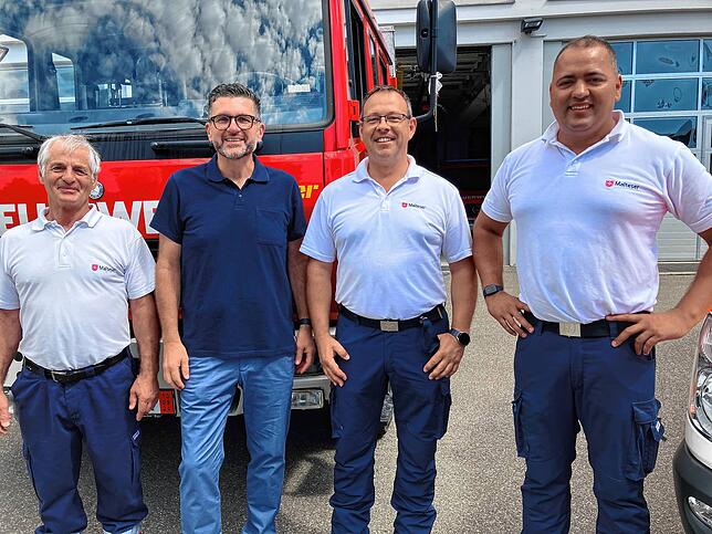 Detlev Willmann (von links), Niko Reith, Benjamin Crain und Rainer Kühl vor dem Feuerwehrfahrzeug, das in die Ukraine überführt wird.