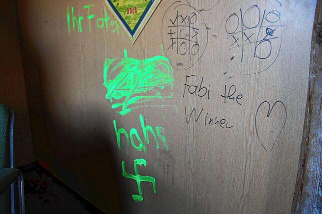 Wüste Beleidigungen und sogar eine Hakenkreuzschmiererei haben die unbekannten Randalierer an der Wand des Jugendtreffs hinterlassen.