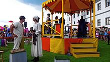 Die Darsteller des Stücks „Uffrur“ (Aufruhr) spielen in und um einen gelben Pavillon, der von allen Seiten von Publikum umringt ist. ...