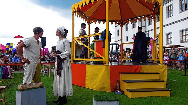 Die Darsteller des Stücks „Uffrur“ (Aufruhr) spielen in und um einen gelben Pavillon, der von allen Seiten von Publikum umringt ist. ...