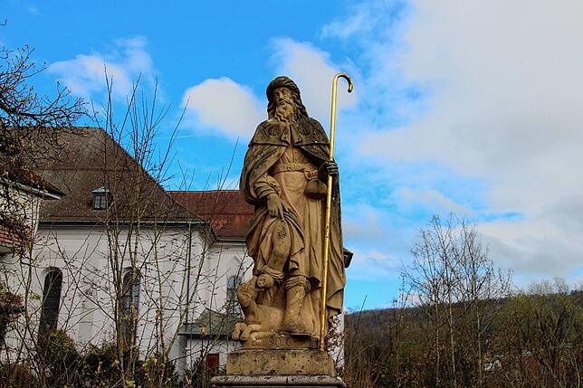 Eine Heiligenstatue vor dem Putz.