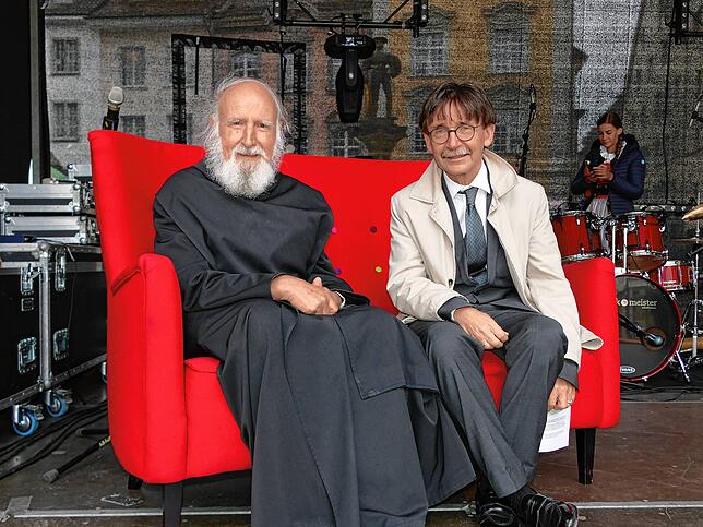 Pater Anselm Grün und Stadtrat Raphaël Rohner (v.l.) sitzen gemeinsam auf der Couch bei der Eröffnung des Kirchentages.