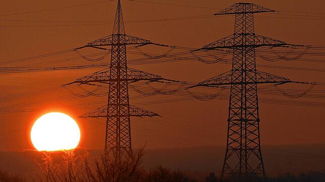 Die Sonne geht hinter Strommasten auf. Die Kosten für den Netzausbau treiben derzeit die Endkundenpreise. Aber nicht jeder Anbieter ...