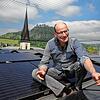 Bene Müller, Chef des Singener Projekt-Planers Solarcomplex, sitzt auf einem Dach mit Solarmodulen.