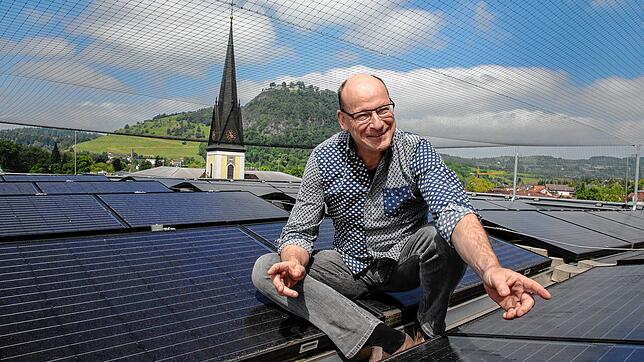 Bene Müller, Chef des Singener Projekt-Planers Solarcomplex, sitzt auf einem Dach mit Solarmodulen.