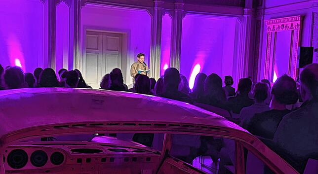 Hinter dem Porsche, der golden strahlt, Daniel Wagner mit Worten prahlt.