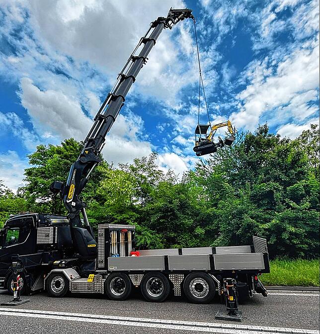 Ein Kran hebt den Bagger aus dem Wasser.