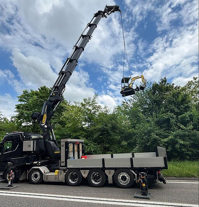 Ein Kran hebt den Bagger aus dem Wasser.