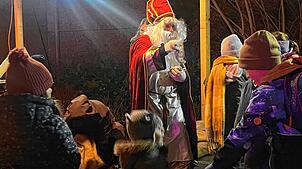 Der sehnsüchtig erwartete Nikolaus verteilt Päckchen an die Kinder