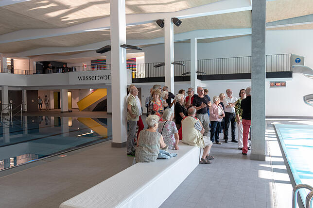 Im Hallenbad angekommen, machten es sich die Besucher auf den Sitzelementen gemütlich, während die Architekten ihre Arbeit erklärten.
