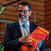 Schulleiter Tobias Andelfinger freut sich über die Geldspende der Elternschaft, symbolisch als „Kohle“ überreicht.