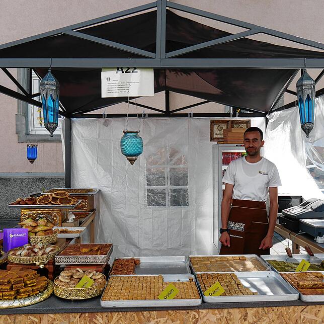 Mohammed Alsalameh verkauft arabische Süßigkeiten und freut sich über reges Interesse der Stadtfest-Besucher.