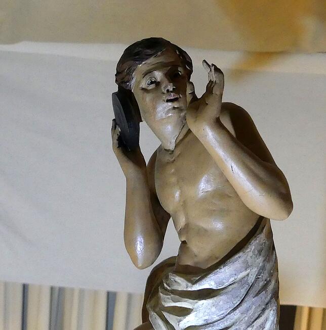 Eine Figur mit Telefonhörer macht die Fortschritts-Symbolik der Uhr deutlich.