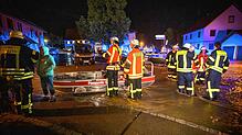 Feuerwehrleute stehen neben einem Feuerwehrboot auf einer Straße in den Fluten eines heftigen Unwetters. Ein Mann war bei den heftigen ...