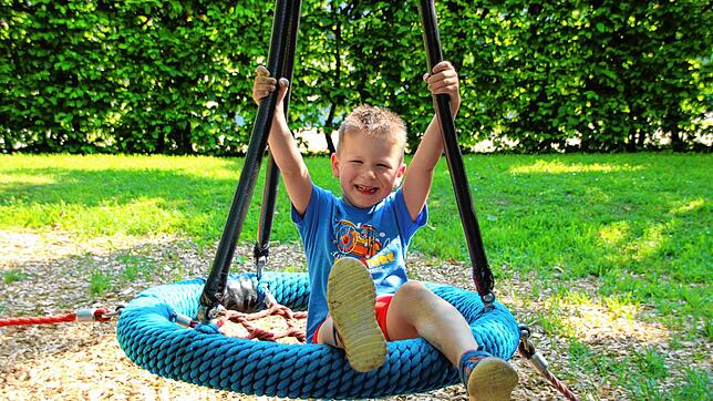 Diego sitzt auf einem Ring mit Fangnetz auf dem Spielplatz neben dem Landratsamt. Er wird bald noch viel mehr zum Lachen haben. Der ...