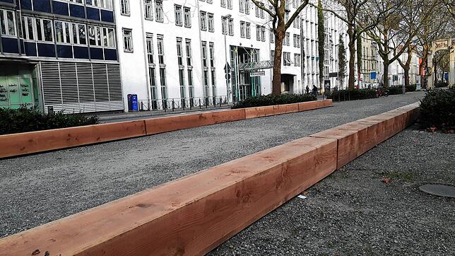 Lange Holzbalken liegen auf dem Mittelstreifen in der Unteren Laube vor dem Technischen Rathaus. Wozu sollen sie gut sein und behindern ...
