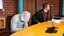 Der Angeklagte zieht seine Kapuze vor Beginn des Prozesses am Freitag, 10. Januar, tief nach unten. Rechts im Bild ist sein Verteidiger ...