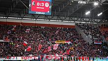 Die Spieler des SC Freiburg stehen vor ihrer Fankurve während darüber die Anzeigetafel mit dem Endstand von 0:3 zu sehen ist.