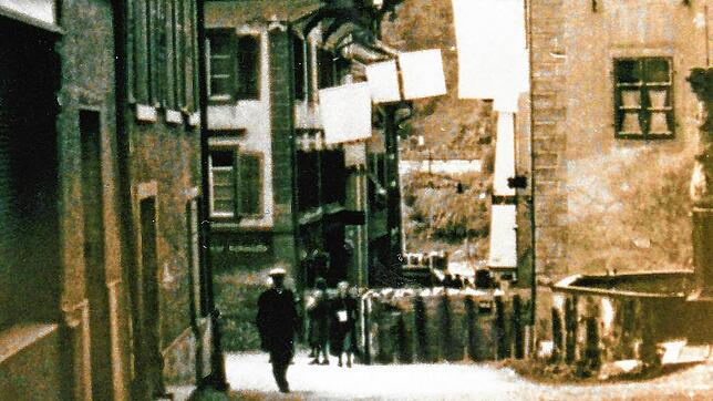 Die untere Hauptstraße in Laufenburg im April 1945: Aus den Fenstern hängen zum Zeichen der kampflosen Übergabe der Stadt weiße Flaggen. ...